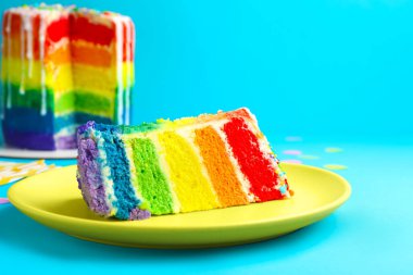 Açık mavi masadaki lezzetli gökkuşağı pastası, yakın plan.