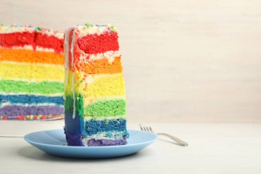 Lezzetli bir parça gökkuşağı pastası beyaz masada, yakın plan. Metin için boşluk