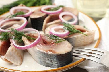 Masada soğan ve dereotlu lezzetli ringa balıkları servis edilir.