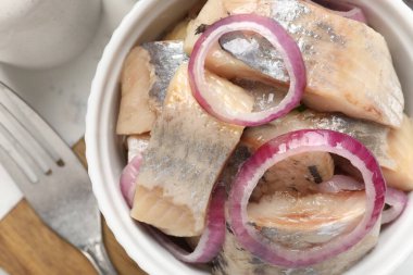 Beyaz masada soğanlı lezzetli ringa balıkları, yakın plan.