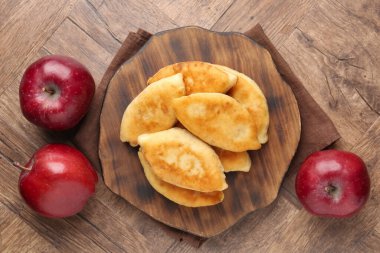 Lezzetli kızarmış pirinçler (doldurulmuş turtalar) ve ahşap masa üzerinde elmalar, düz uzanmış