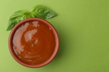 Yeşil arka planda lezzetli köri sosu ve fesleğen yaprakları, üst manzara. Metin için boşluk