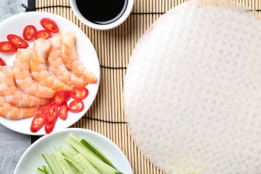 Pirinç kağıt çarşaflar ve açık gri masa üzerindeki farklı malzemeler, düz uzanmış.