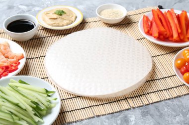 Pirinç kağıt çarşaflar ve açık gri masa üzerindeki farklı malzemeler, yakın plan.