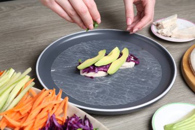 Gri ahşap masada nefis börek yapan kadın, yakın plan.