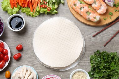 Pirinç kağıt çarşaflar ve gri ahşap masa üzerindeki farklı malzemeler.