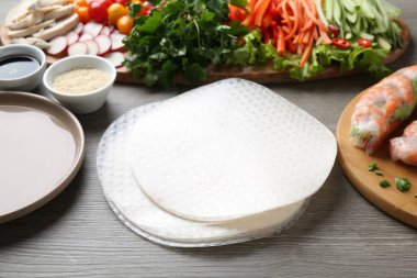 Pirinç kağıt çarşaflar ve gri ahşap masa üzerindeki farklı malzemeler. Yakın plan.