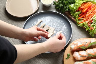 Gri ahşap masada nefis börek yapan kadın, yakın plan.