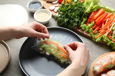 Gri ahşap masada nefis börek yapan kadın, yakın plan.