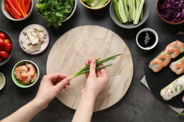 Koyu gri masada nefis börek yapan bir kadın.