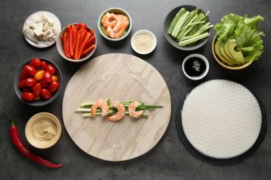 Pilav kağıtları ve farklı malzemeler koyu gri masada, düz yerde.