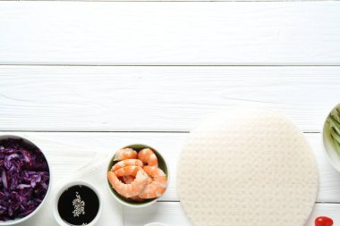 Pilav kâğıdı çarşafları ve beyaz ahşap masa üzerindeki farklı malzemeler. Metin için boşluk