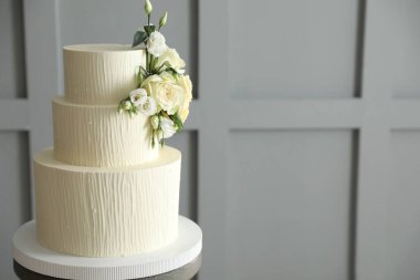 İçerideki masada çiçek desenli nefis düğün pastası, mesaj için yer var.