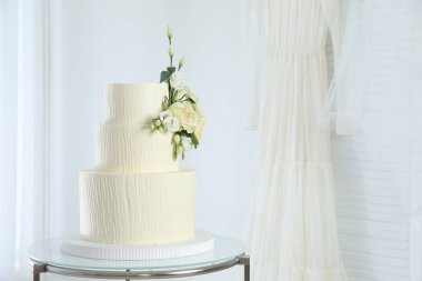 İçerideki masada çiçek desenli nefis düğün pastası, mesaj için yer var.