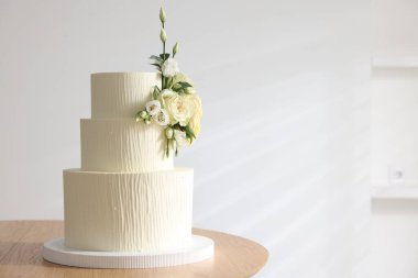 İçerideki ahşap masada çiçek desenli nefis düğün pastası, mesaj için yer.