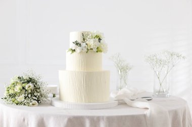 Çiçekli düğün pastası ve kapalı masa desenli lezzetli bir pasta.