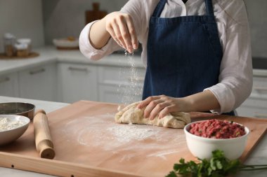 Khinkali yapıyorum. Mutfakta hamur yoğuran kadın, yakın plan.