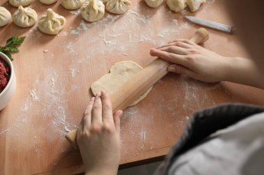 Kadın mutfaktaki masada khinkali yapıyor.