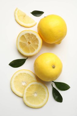 Beyaz arka planda taze olgun limonlar, düz uzanmış.