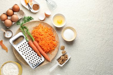 Bej desenli masa üzerinde havuçlu kek yapmak için farklı malzemeler. Metin için boşluk