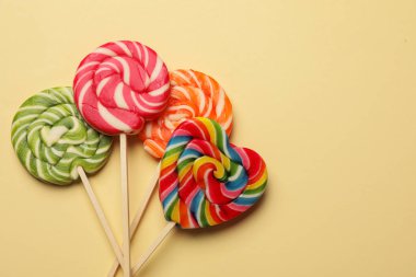 Bej arka planda leziz lolipoplar, düz yatış. Metin için boşluk