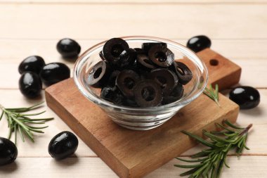 Lezzetli marine edilmiş zeytin halkaları, bütün olanlar ve biberiye açık ahşap masada, yakın plan.