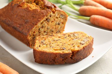 Açık gri masada fındıklı ve sebzeli ev yapımı havuçlu kek, yakın plan.