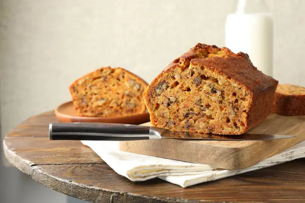 Ev yapımı havuçlu kek, fındıklı ve bıçaklı, ahşap masa, yakın plan.