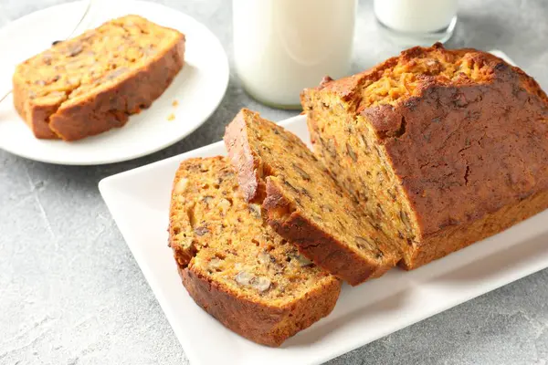 Ev yapımı havuçlu kek, fındıklı ve sütlü gri masa, yakın plan.