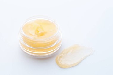 Beyaz arka planda kavanoz ve dudak kremi örneği, yakın plan.