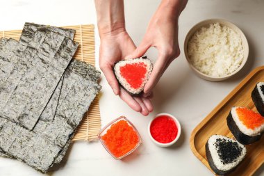 Lezzetli tobiko onigiri (Japon pirinç topları) olan kadın beyaz mermer masa, üst görünüm