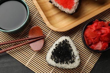 Lezzetli tobiko onigiri (Japon pirinç topları) siyah masada servis edilir.