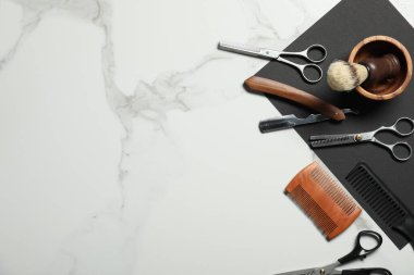 Beyaz mermer masa üzerinde birçok farklı berber aletleri, düz yatıyordu. Metin için boşluk