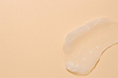 Bej arka planda nemlendirici dudak kremi, üst manzara. Metin için boşluk