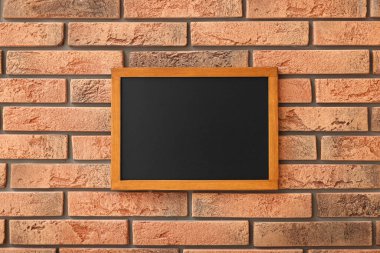 Tuğla duvarda boş küçük bir tahta.