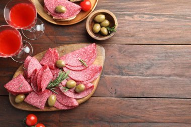 Tahta masada servis edilen zeytinli ve biberiyeli leziz sosis dilimleri. Metin için boşluk