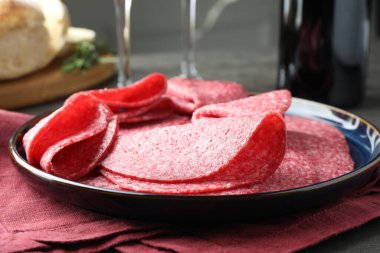 Gri masada servis edilen lezzetli sosisler, yakın plan.