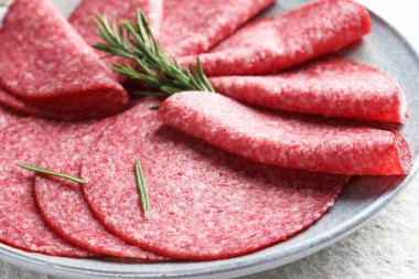 Beyaz desenli masada servis edilen biberiyeli leziz sosis dilimleri.