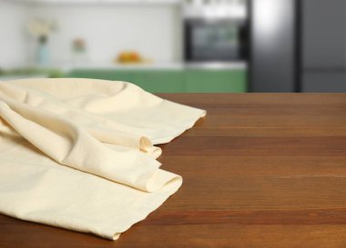 Mutfaktaki ahşap masada bej masa örtüsü, yazı için yer. Ev tekstili