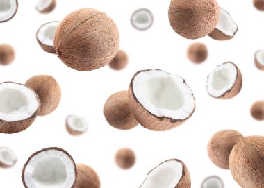 Beyaz arka planda uçan bir sürü taze hindistan cevizi.