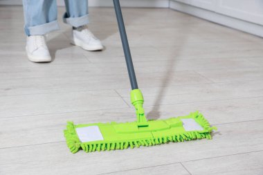 Yerleri paspasla temizleyen kadın, yakın çekim.