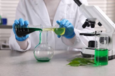 Biyokimya. Laboratuvarda, gri masada bitki ve sıvılarla çalışan bilim adamı.