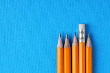 Açık mavi arka planda bir sürü kalem, üst manzara. Metin için boşluk