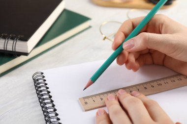 Işık masasında cetvel ve kalemle çizim yapan kadın, yakın plan.