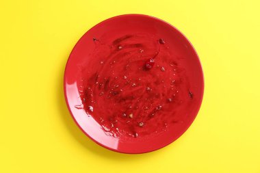 Sarı arka planda kirli bir tabak, üst manzara.