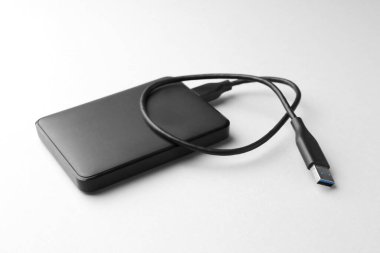 Beyaz arkaplanda USB kablosu olan harici sabit disk, kapat