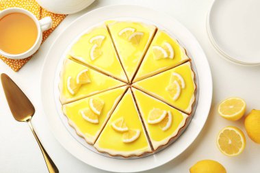 Beyaz masada servis edilen leziz limonlu cheesecake.
