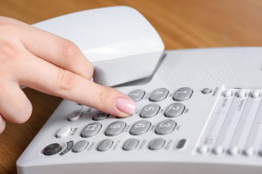 Ahşap masada telefonla arayan kadın, yakın plan.