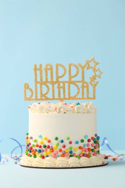Delicious bento cake with colorful sprinkles, topper and serpentine streamer on white table