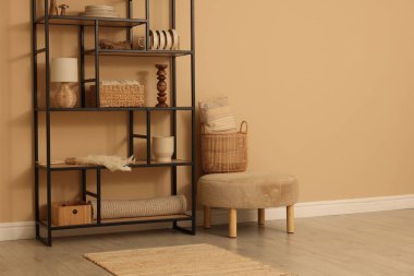 Dekor, sepet ve yastıklı raf ünitesi bej duvarın yanında.